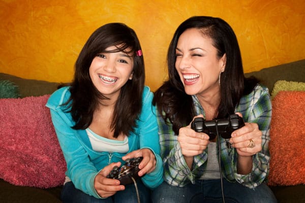 hispanic-woman-and-teenage-daughter-playing-video-game